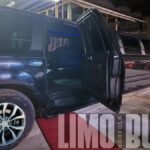 Black 14-passenger SUV limousine with open door and red carpet entrance at Norfolk Limo Bus.