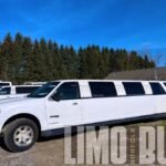 Side view of 14-passenger white SUV limousine with tinted windows parked in Norfolk