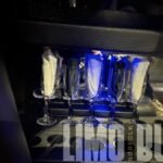Close-up of champagne glasses neatly arranged inside the Norfolk SUV limo.