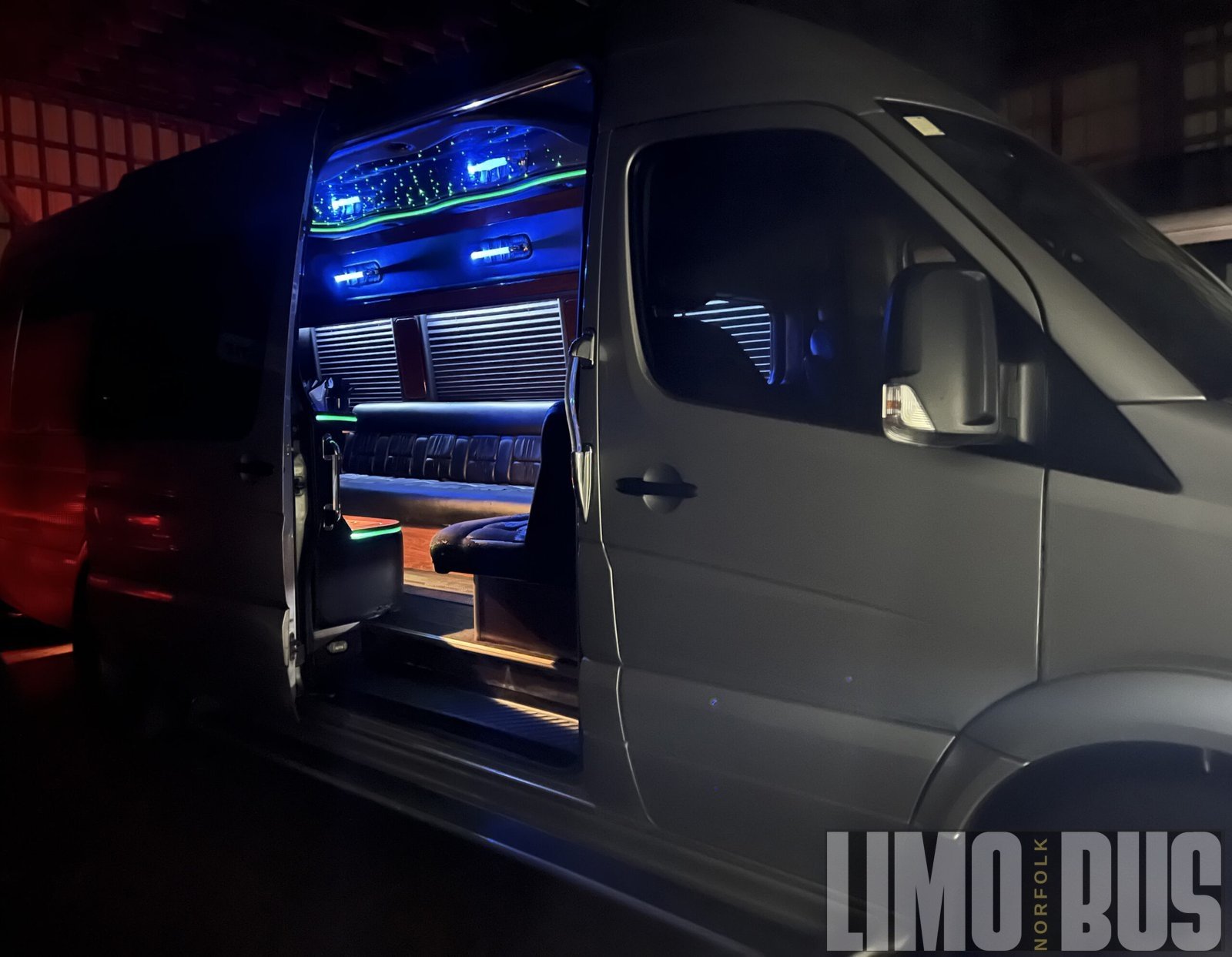 Spacious 15-passenger party bus interior with LED lighting, premium leather seating, and luxury features from Limo Bus Norfolk.