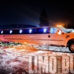 22-passenger stretch SUV limo in Norfolk illuminated with vibrant LED exterior lights at night.