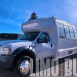 Side angle showcasing the Ford party bus with large tinted windows for privacy and style.