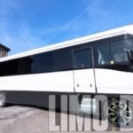 White 38-passenger party bus parked outside, ideal for weddings, corporate transportation, and group events across Norfolk.