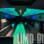 Luxurious 50-passenger party bus interior with glowing green LED lights, black leather seating, and sleek modern design for Norfolk events.