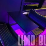 Table and lounge seating setup inside a 50-passenger party bus, ideal for work sessions, wine tours, and group celebrations.